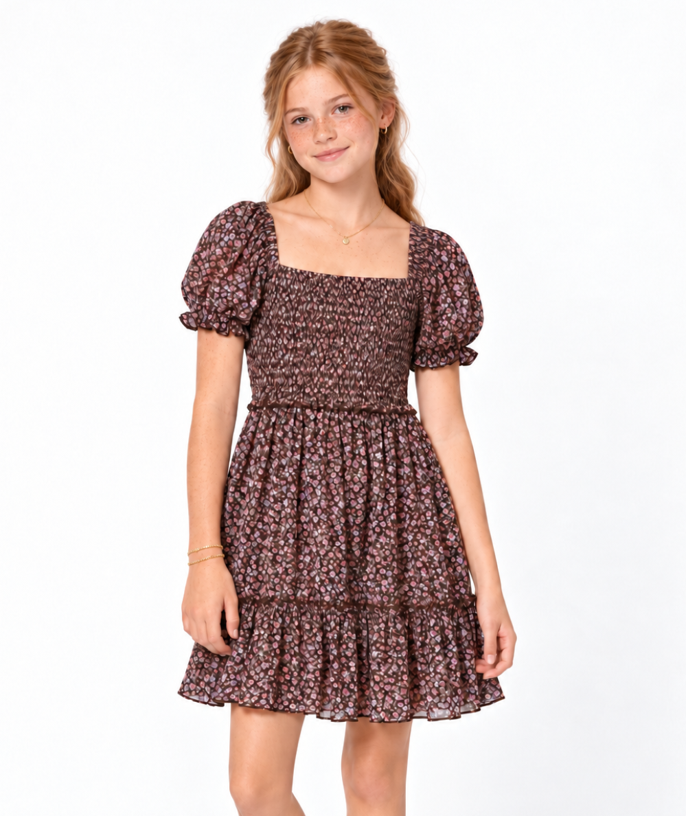 Model wearing the KatieJ NYC Tween Molly short-sleeve dress in Espresso Floral with a smocked bodice, puff sleeves, square neckline, and tiered ruffle hem