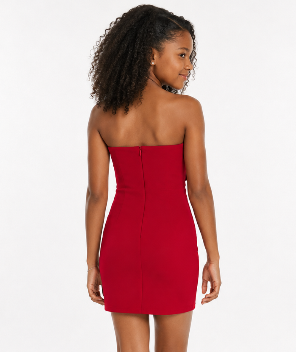 Back view of a young model wearing the Gold Rush NYC Tween Teddie Bow Dress in Red with a center zipper and fitted silhouette.
