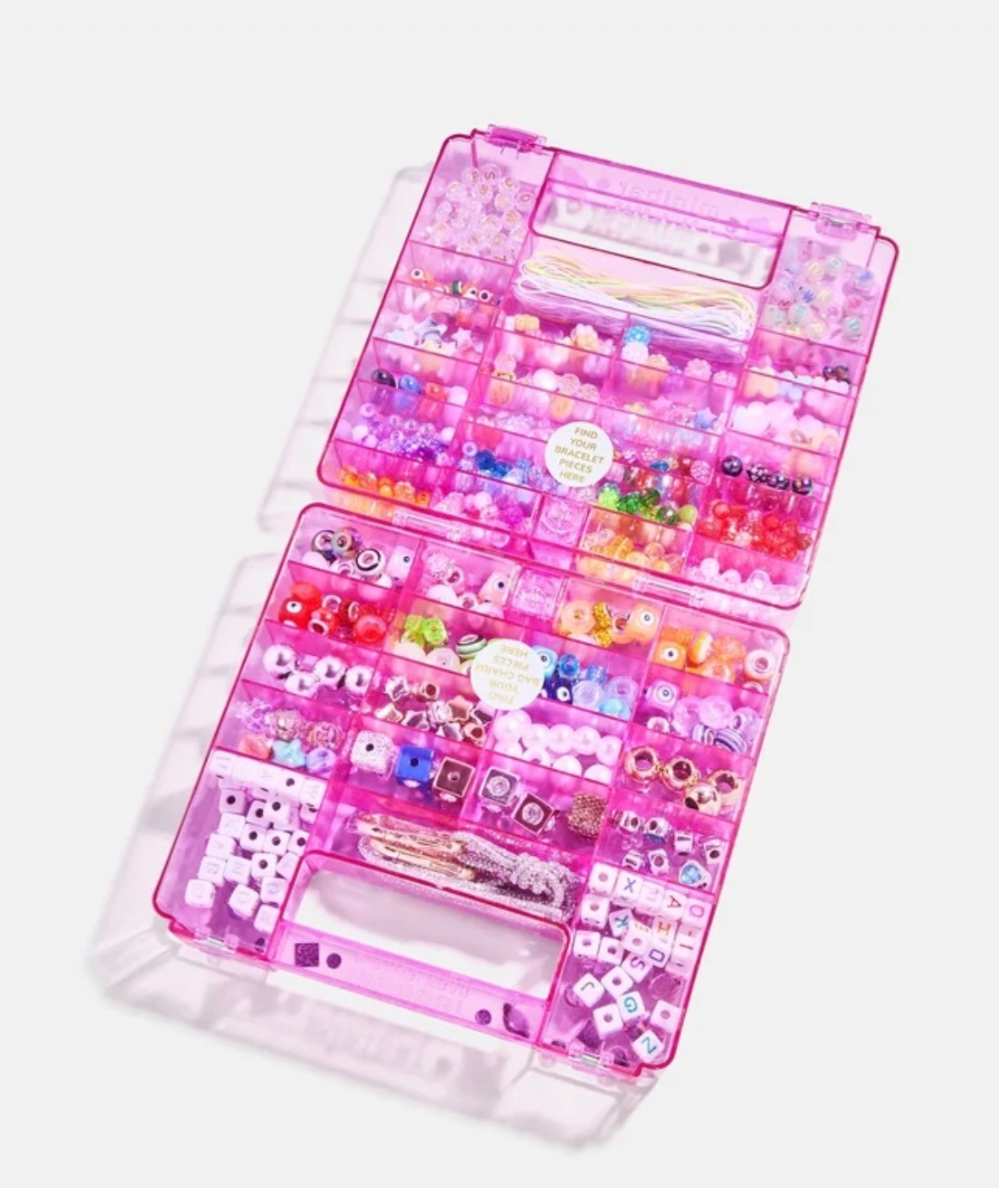 Interior of BaubleBar Dream Duo Kids’ DIY bracelet and bag charm kit with gem-covered reusable case In pink. 
