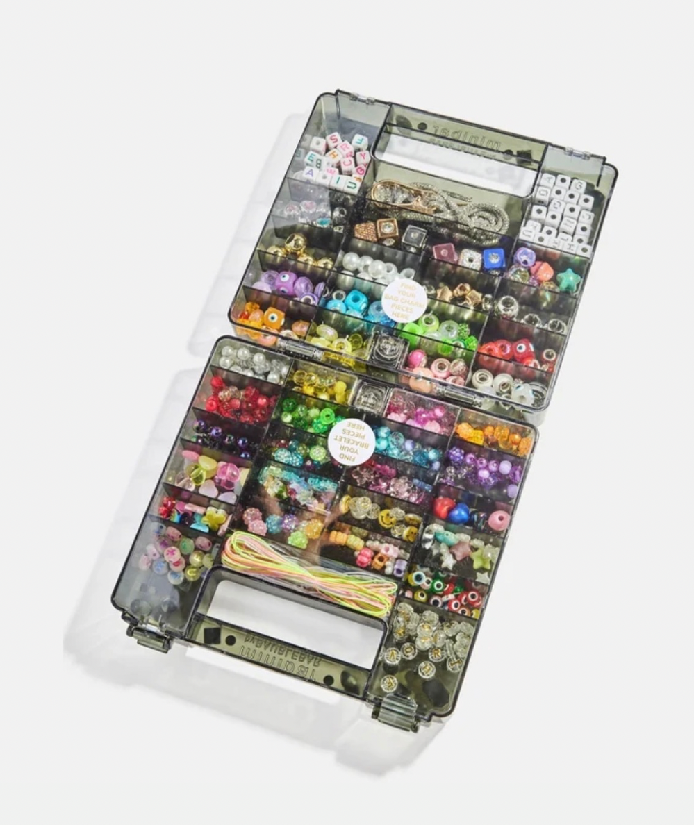 Interior of BaubleBar Dream Duo Kids’ DIY bracelet and bag charm kit with gem-covered reusable case In black. 