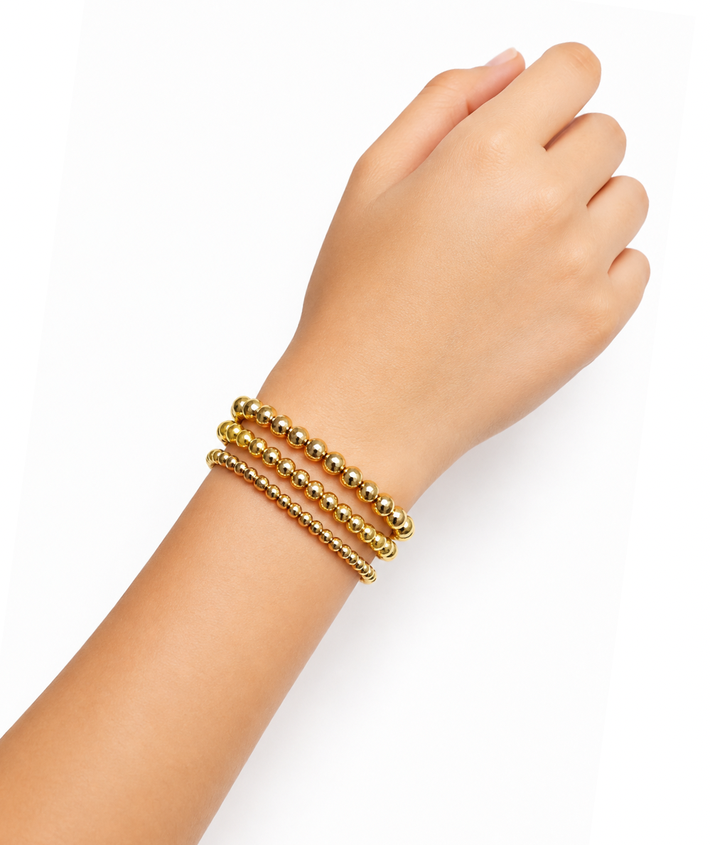 Tween model wearing the Ellison + Young Keep It Forever set of three 18K gold-plated beaded stretch bracelets in 3 mm, 4 mm and 5 mm sizes.