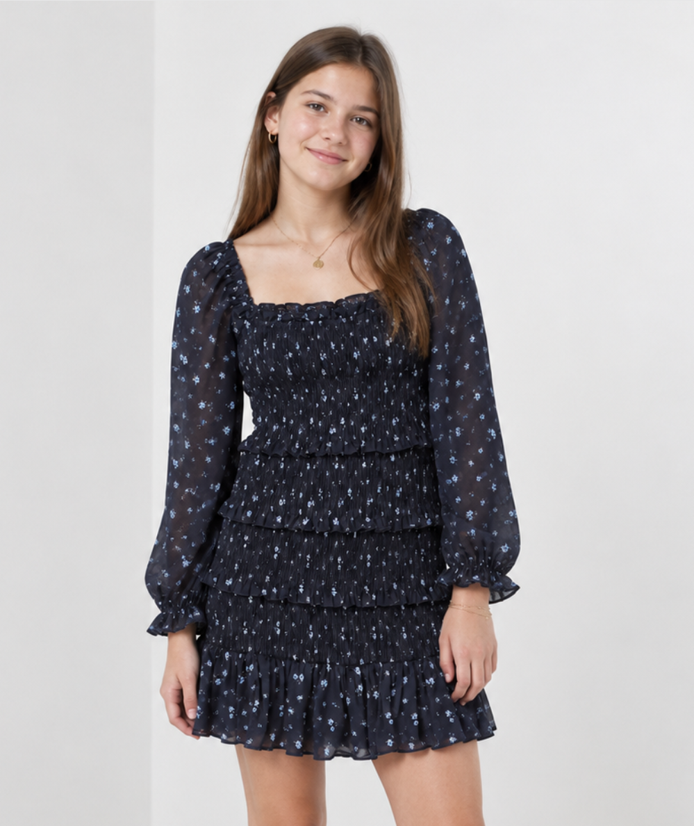 Teen model
Wearing the KatieJ NYC Junior Laila Long Sleeve Floral Dress in Evening Blue Garden with blue flowers, smocking, puff sleeves and tiered ruffles.