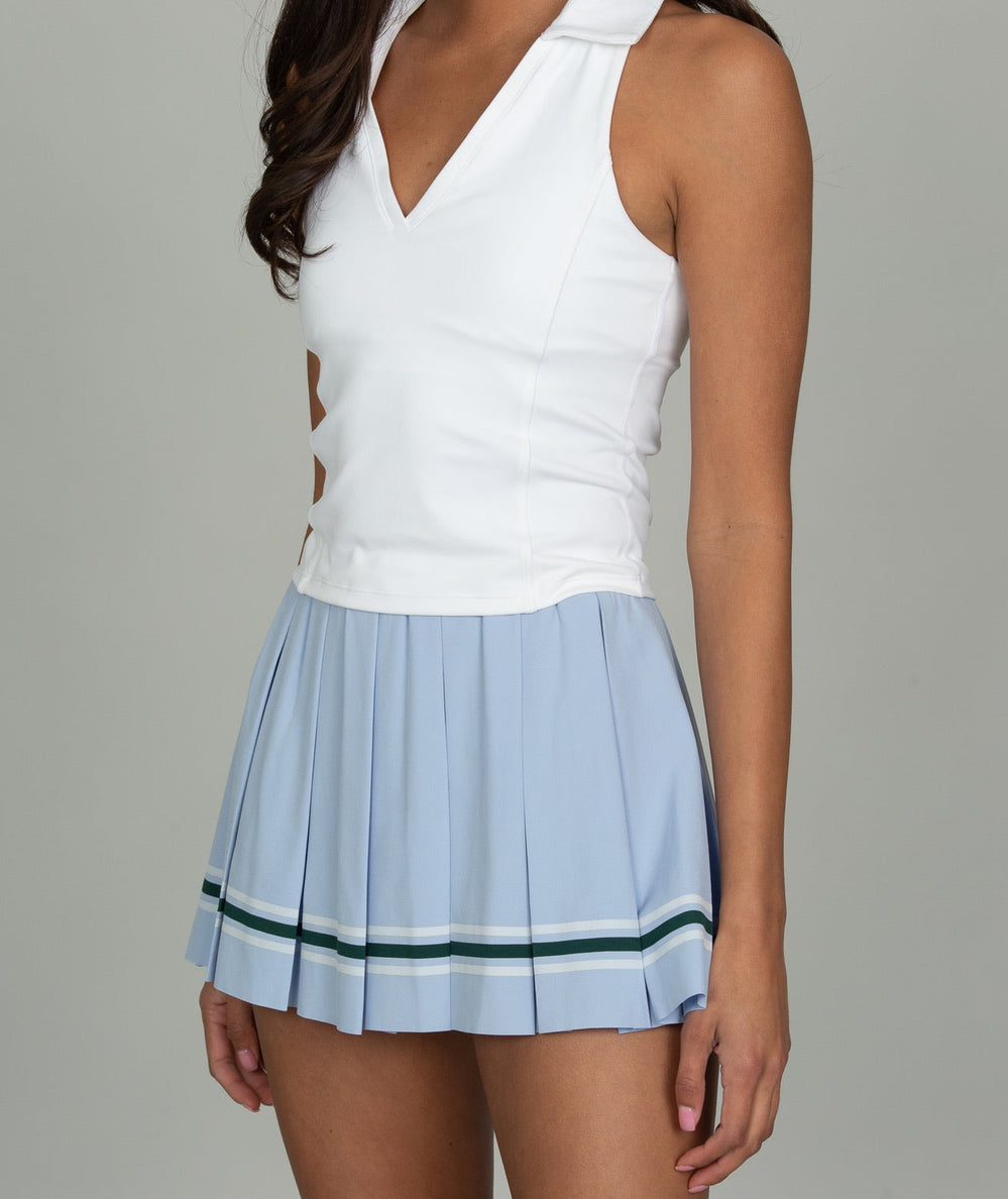 Model wearing the Gold Hinge Striped Mini Pleated Skirt in Powder Blue with a white V-neck polo tank - CAKEWISH.