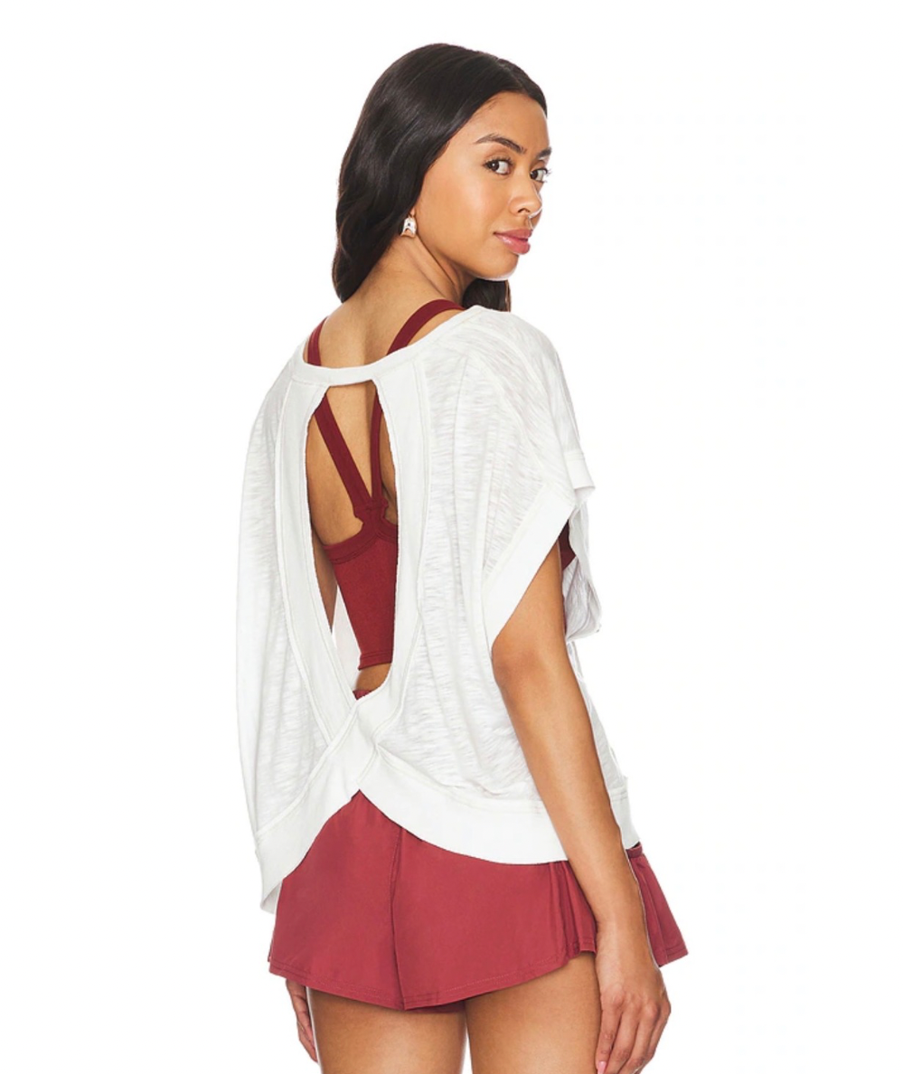     Back view of the FP Movement My Time Tee in white, showing the wrapped cutout detail over a burgundy sports bra.