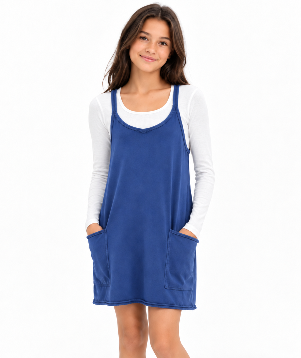 Model wearing the True Navy Free People Movement Hot Shot Mini Dress over a white long sleeve tee, showing the front patch pockets.