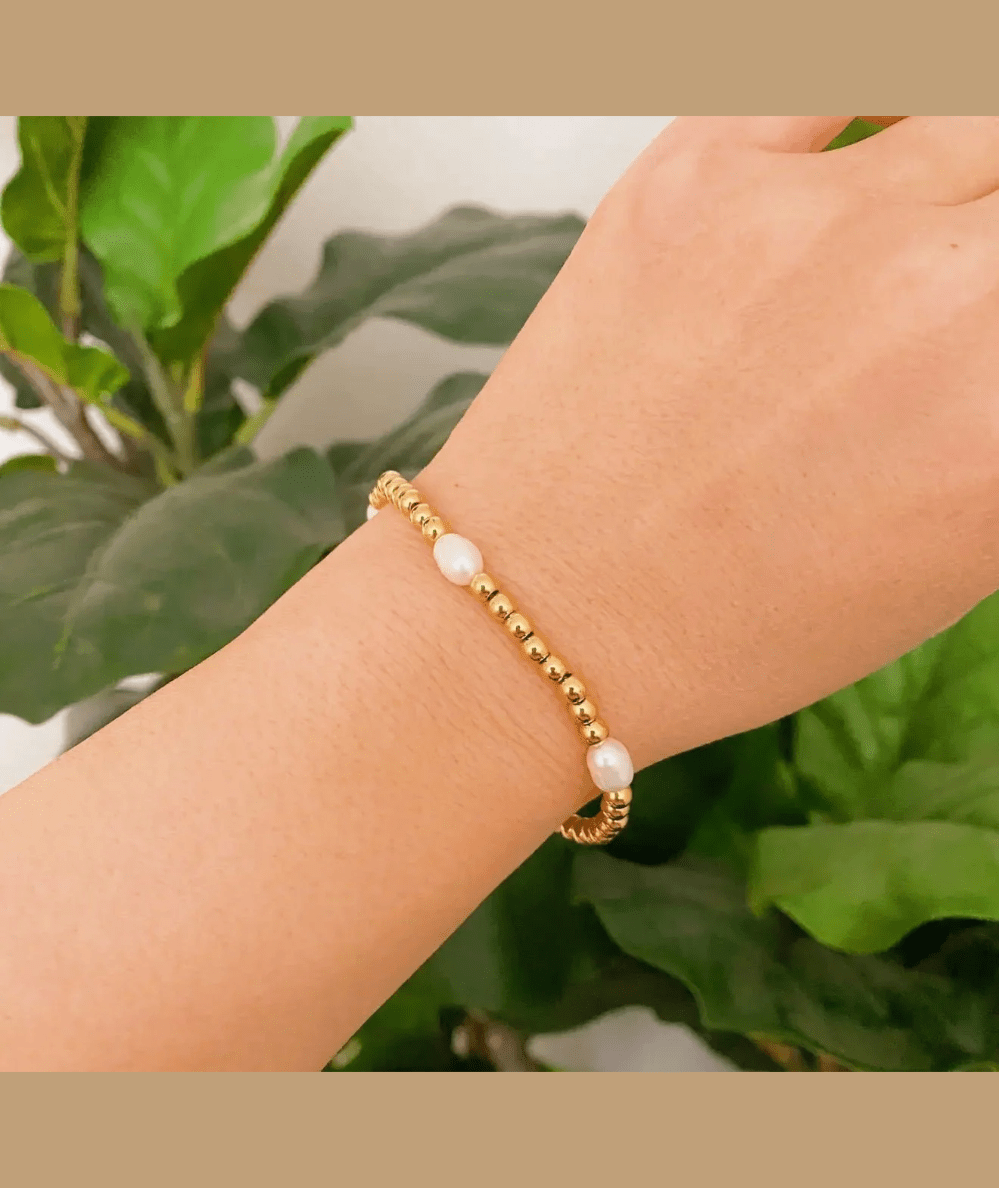 Freshwater pearl and gold bead bracelet worn on the wrist, by Ellison + Young - CAKEWISH.