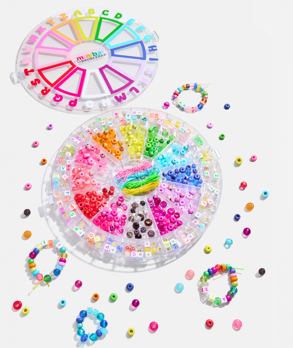 Spinning storage case with labeled letter compartments in the BaubleBar Craft By Letter Kit - CAKEWISH.