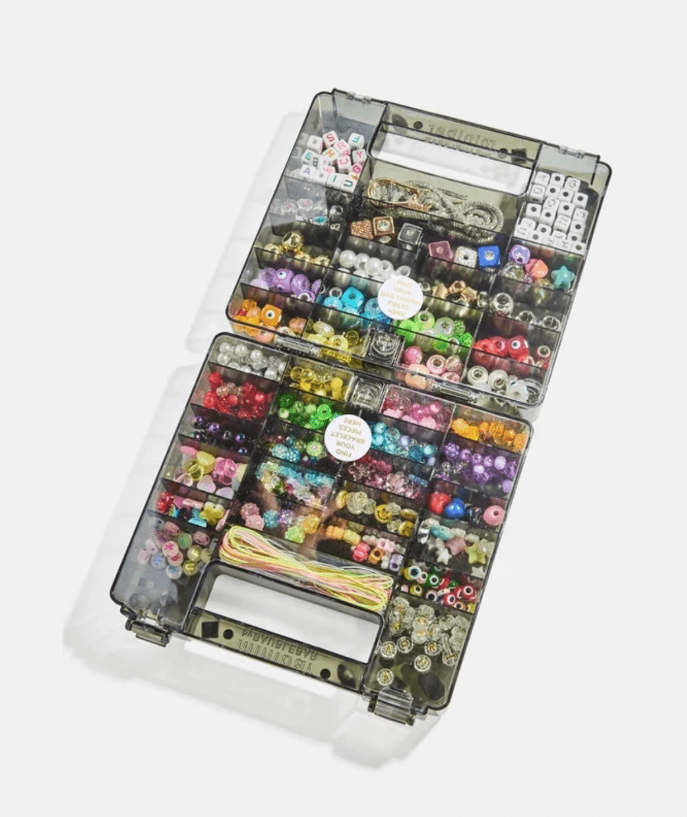 Open black Dream Duo case with letter beads and rainbow beads sorted in compartments.