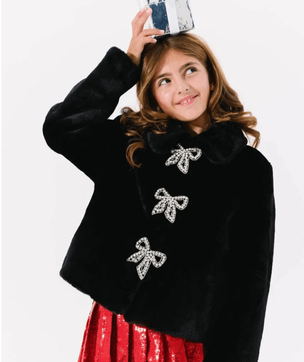 Model wearing the Lola & the Boys Black Tween Audrey Faux Fur Coat with Rhinestone Bows - CAKEWISH