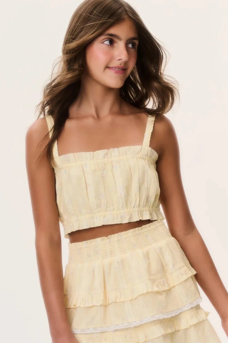 Close up of model wearing the LoveShackFancy Tween Ditsy Floral Ken Top in Lemon Haze