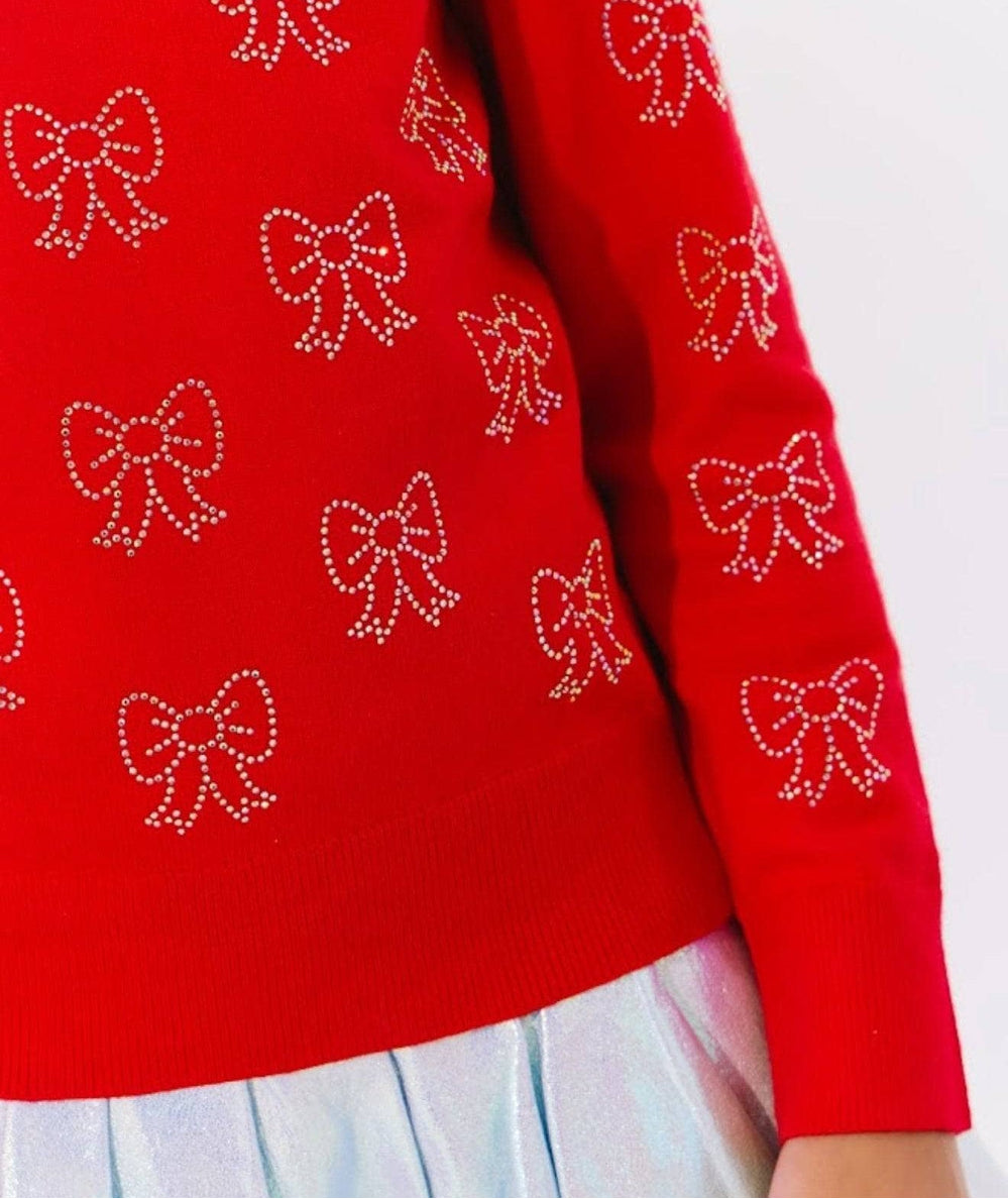 Close up of the crystal bow details on the ruby red knit sweater sleeve by Lola and the Boys - CAKEWISH.