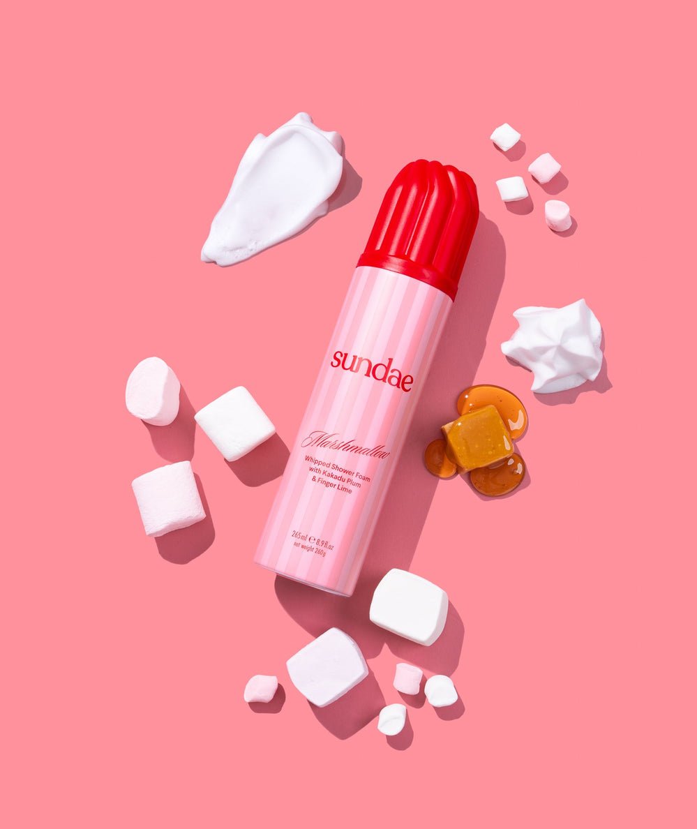 Pink Marshmallow Whipped Shower Foam can with a red cap surrounded by marshmallows and caramel pieces by Sundae Body - CAKEWISH.