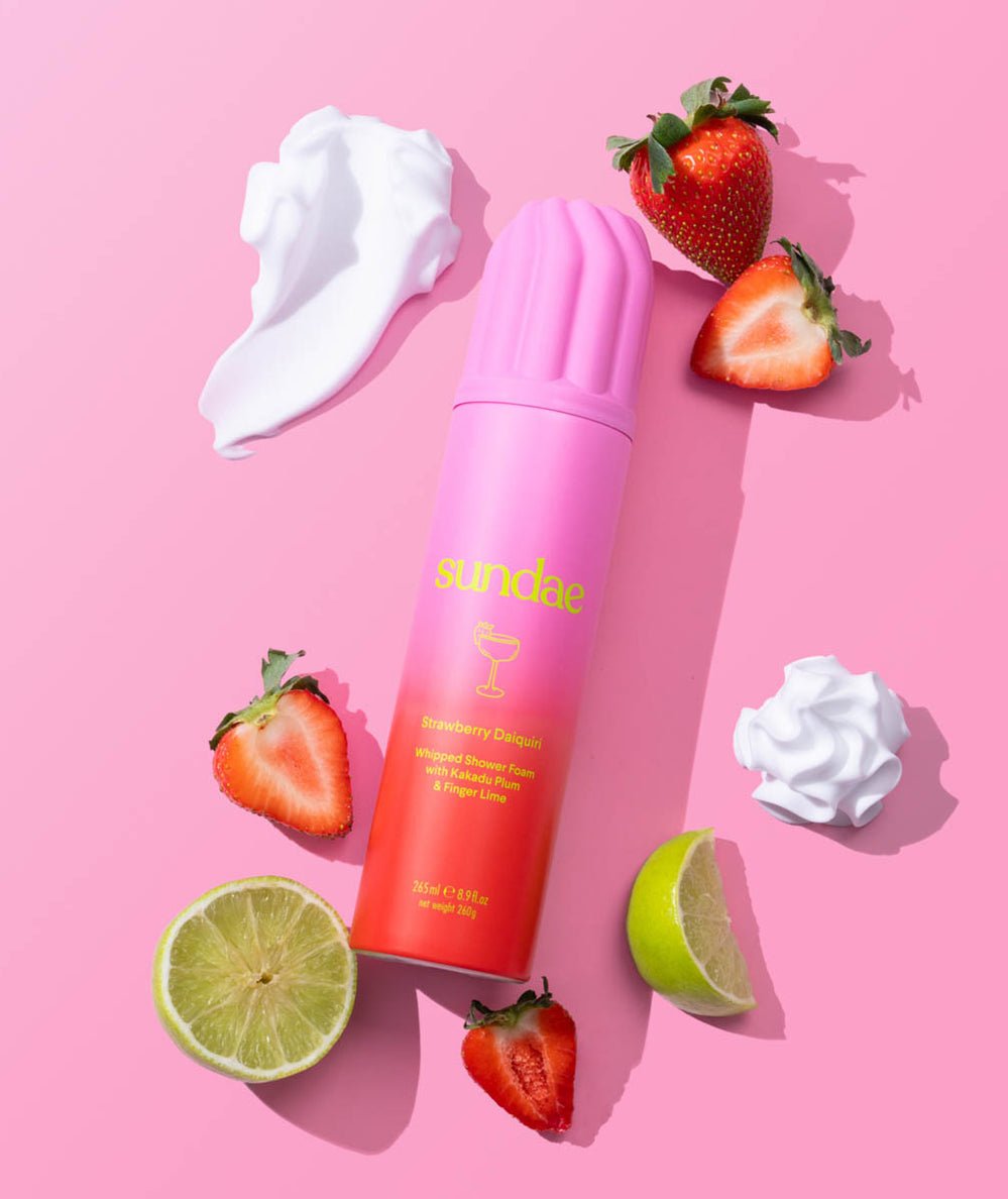 Pink-to-red ombre Strawberry Daiquiri Whipped Shower Foam can with fresh strawberries and lime slices by Sundae Body - CAKEWISH.